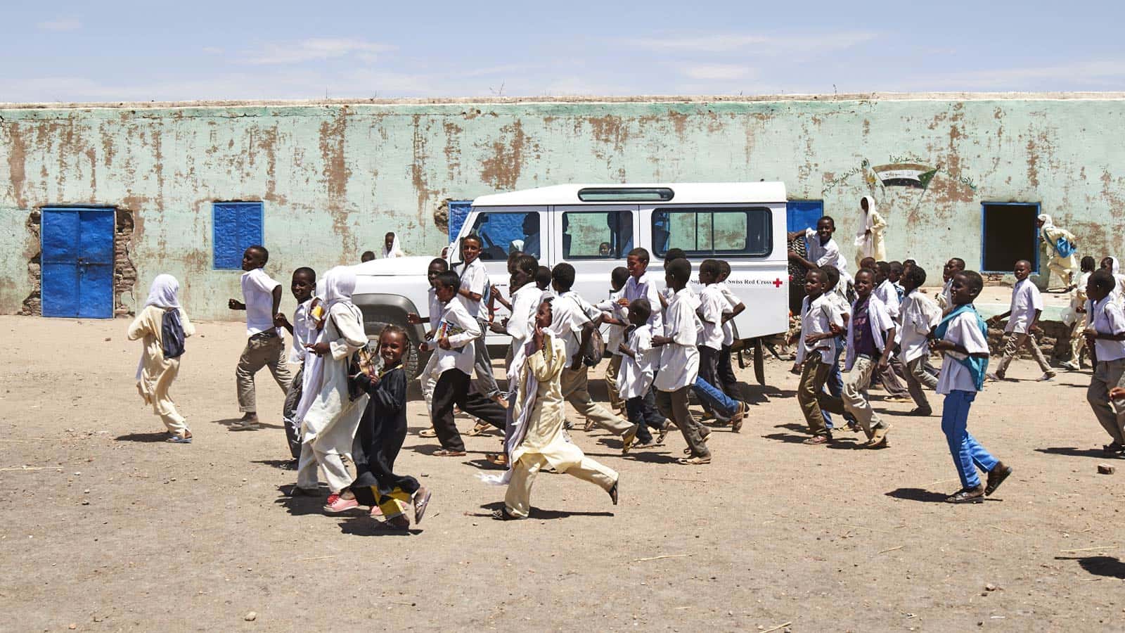 Children surrounding a Land Rover Defender