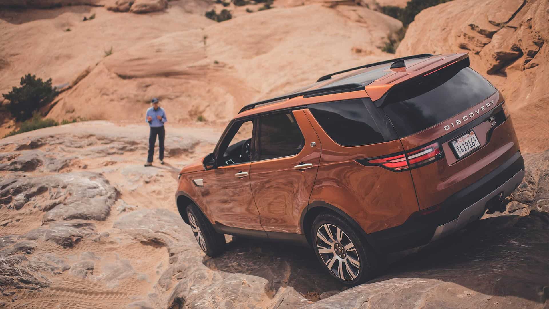 Orange Discovery driving over rocky terrain
